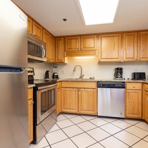 Kitchen featuring wooden cabinetry, granite countertops, and a bar area, perfect for preparing meals and entertaining