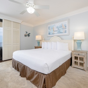 Soft layers and gentle lighting create calm in the master suite with a king bed and serene art above