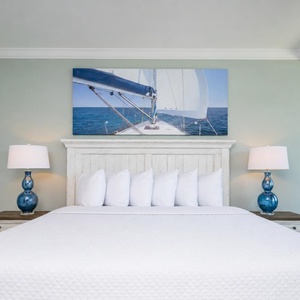 Experience restful nights in this master bedroom with a king bed, soft linens, and nautical art