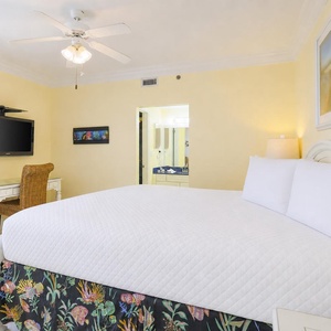 Cozy master bedroom features a plush king bed, a workspace with complimentary WiFi, and a view of the balcony