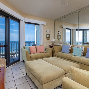 Cozy living area features a large sectional sofa with queen sleeper, offering views of the gulf through expansive windows
