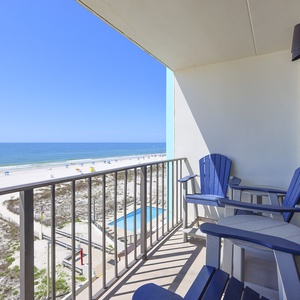 Enjoy stunning beachfront views from this balcony featuring comfortable seating, perfect for relaxation and unwinding