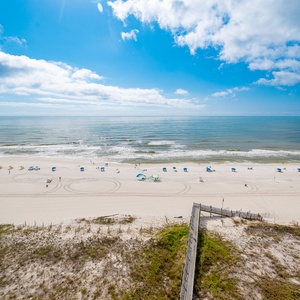 A vibrant beach view showcases colorful umbrellas dotting the white sand, inviting guests to relax by the tranquil waves