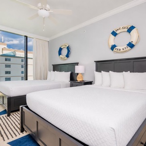 Experience comfort in this inviting guest bedroom with two queen beds, nautical decor, and stunning views