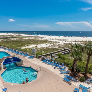 Relax by the inviting pool area surrounded by lounge chairs, with beautiful beach views