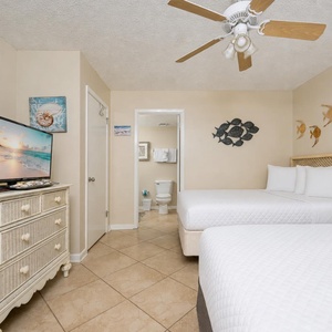 Artful fish sculptures add coastal charm as you rest on two queen beds in the guest suite