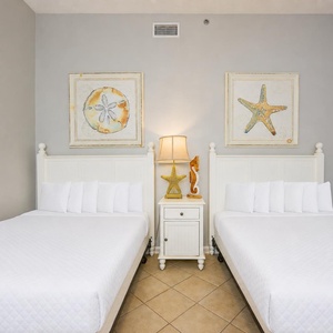 Rest peacefully in this cheerful guest bedroom with two double beds, surrounded by playful coastal decor