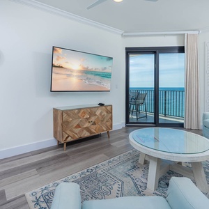 Unwind in the airy living space with a large TV, stylish decor, and beachfront balcony access