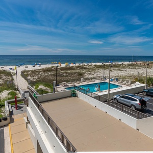 Enjoy stunning beachfront views from this inviting balcony overlooking the pool and sandy shores