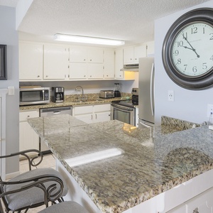 This inviting kitchen features granite countertops, stainless appliances, and a cozy seating area for enjoying meals together