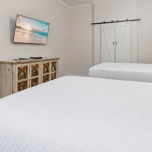 Unwind in this guest bedroom with two queens, where plush bedding invites restful nights and relaxation