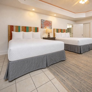 Enjoy restful nights in this spacious bedroom featuring two cozy queen beds and cheerful coastal decor