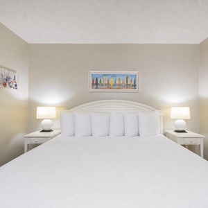 White linens await in the master suite where soft lamps frame restful nights after beach adventures