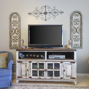 This inviting living area features a cozy blue chair, vintage-style decor, and a TV for entertaining