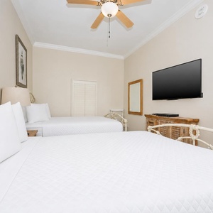 Comfortable guest bedroom with two cozy queen beds, a TV, and charming decor for a restful stay
