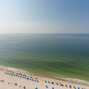 Step onto the balcony and listen to soft gulf waves while watching rows of blue umbrellas dotting the shore