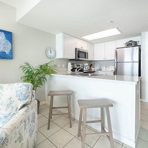 Enjoy the open kitchen and living area with a comfortable sofa, bar seating, and coastal-themed decor