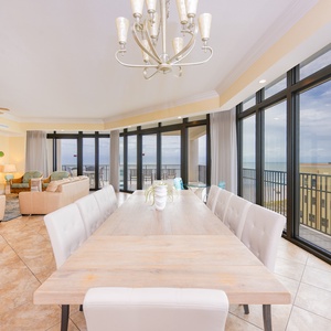 Spacious living area featuring a dining table for ten, cozy seating, and panoramic views through large windows