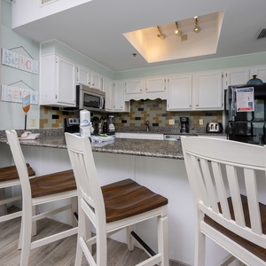 This kitchen features granite countertops, stainless appliances, and a cozy bar area with seating, perfect for casual dining