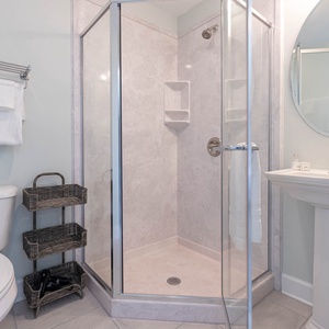 Enjoy a warm spray in the glass shower in this relaxing guest bathroom