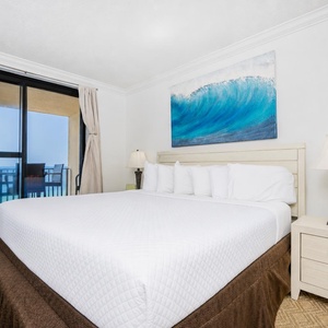 Relax in the spacious master bedroom with a king bed, tasteful decor, and beachfront balcony access
