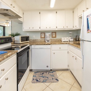 Welcoming kitchen featuring granite countertops, modern appliances, and a cozy shark-themed mat for added charm