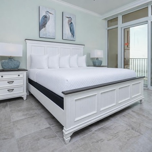 Retreat to the king master suite with cozy bedding and drift off to the sound of the waves from the balcony