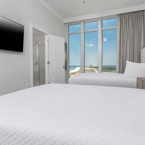 Stretch out on the queen beds and watch the gulf through tall windows from this guest suite