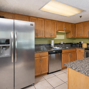 Kitchen featuring wooden cabinetry, granite countertops, and stainless appliances, creating a welcoming cooking space