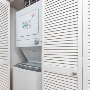 This laundry area features a stacked washer and dryer behind louvered doors for convenient in-unit laundry access