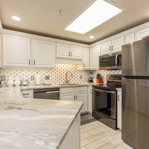 Cook and gather in this stylish kitchen featuring sleek appliances, elegant countertops, and ample storage space