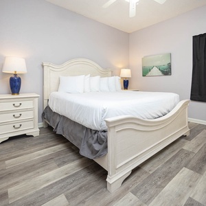 Bright and airy bedroom featuring a king bed, stylish nightstands, and a serene coastal artwork
