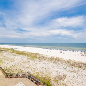 Relax by the poolside under shaded canopies, enjoying views of the beach and comfortable lounge seating