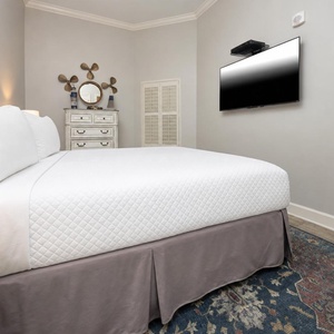 This cozy guest bedroom features a plush king bed, a mounted TV, and nautical decor that enhances the relaxing atmosphere