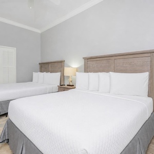 Inviting guest bedroom featuring two queen beds, soft bedding, and charming coastal decor