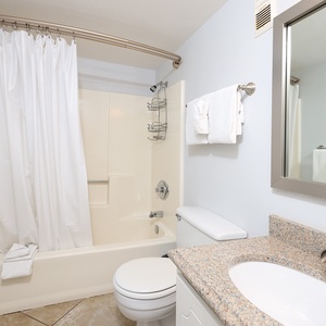 This bathroom features a clean design with a spacious tub, modern fixtures, and fresh towels for a refreshing experience