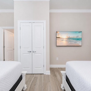 Relax in this guest bedroom with two queen beds and a TV for a calming vibe