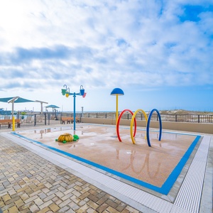 Enjoy the vibrant splash park area, perfect for family fun, with colorful play equipment and beach nearby