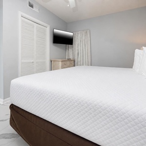 Rest in the comfortable bedroom with a king bed, a TV for entertainment, and soft lighting for a peaceful atmosphere