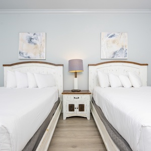Drift into restful nights on plush queen bedding, embraced by soft linens and calming decor in this inviting guest room