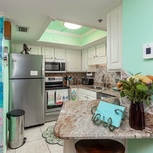 Exciting kitchen featuring stainless appliances, colorful decor, and a cozy breakfast nook with floral accents