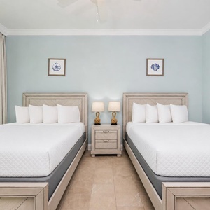 Soothing guest bedroom featuring queens, soft linens, and beach views