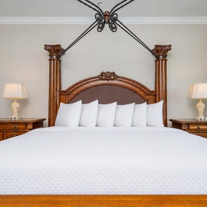 The master suite features a grand king bed, decorative lamps, and soft pillows for a restful sleep
