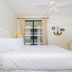 This inviting bedroom features a plush king bed, light-colored decor, and a TV, creating a relaxing retreat