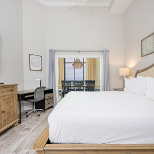 Master bedroom featuring a plush king bed, modern workstation with complimentary WiFi, and a lovely view of the dining area