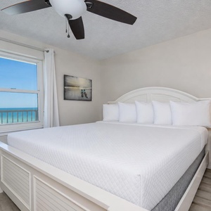 White linens dress the king bed in the master suite where gentle coastal sounds soothe your rest