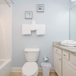 Fresh towels await your post-adventure refresh in this guest bathroom with soft coastal accents