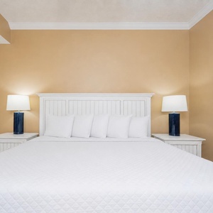 Two lamps cast a gentle glow over your king suite's plush bed ready for restful sleep