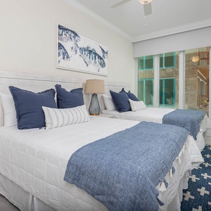 Settle onto the queen beds and take in gulf views through the wide window in this guest suite