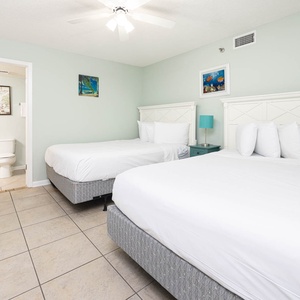 Inviting guest bedroom featuring two queen beds, stylish decor, and a soothing color palette